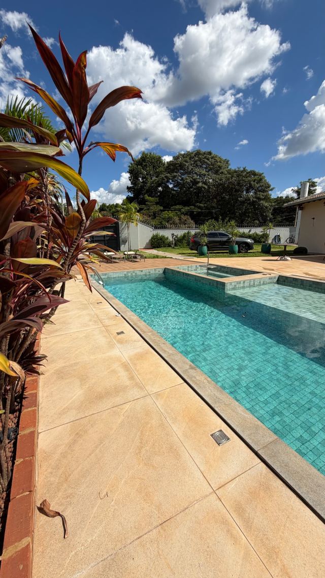Piscina e jardim tropical em dia de sol