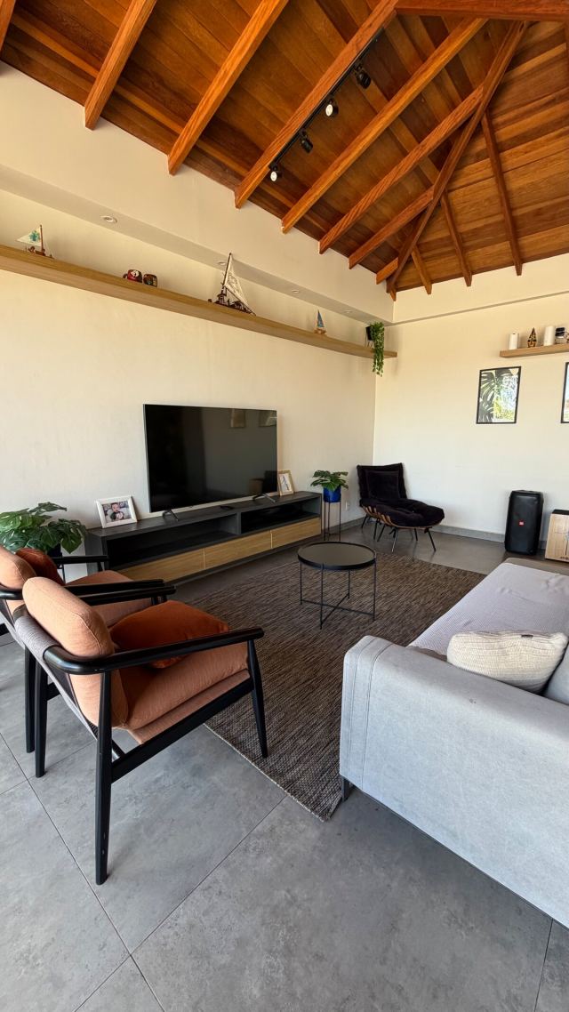 Sala de estar com TV, sofá e poltronas