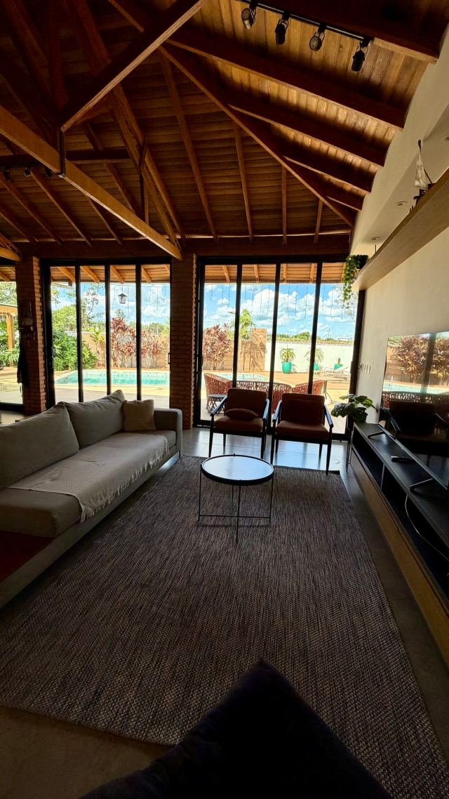 Sala de estar com vista para a piscina pelas portas de vidro