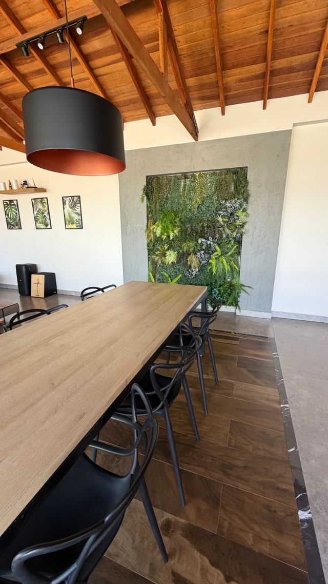 Mesa de jantar comprida no salão, com jardim vertical