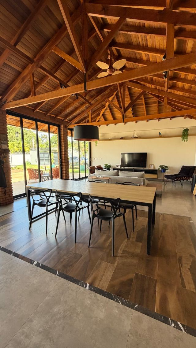Mesa de jantar no salão, com a sala de estar ao fundo